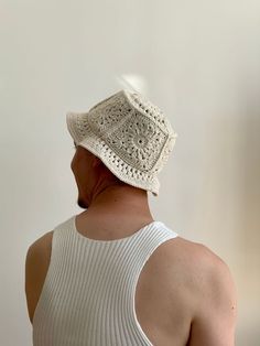 a man wearing a white knitted hat looking off into the distance with his back to the camera