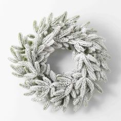 a white wreath with green leaves on it