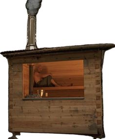 a person sitting in a wooden sauna with a light on the top and bottom