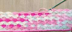 a crocheted pink and white piece of cloth