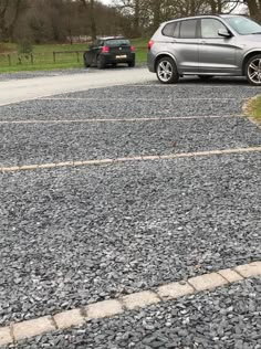 two cars parked in a gravel parking lot