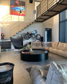 a living room filled with lots of furniture and a motorcycle parked on the wall behind it