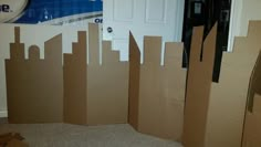 a cardboard castle made to look like a cityscape with a clock on the wall