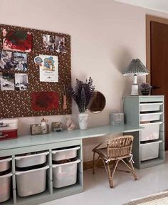 a room with several storage bins and baskets on the wall next to a desk