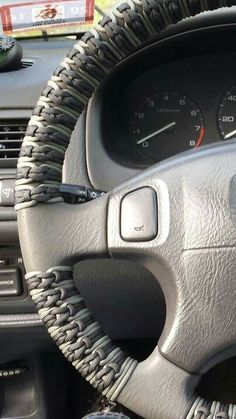 the steering wheel and dash board of a car with braids on it's dashboard