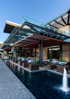 an outdoor dining area with water fountain and tables