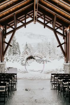 the inside of a wooden structure with chairs and tables set up for an outdoor ceremony