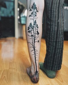 a person with a tree tattoo on their leg