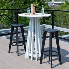 three stools and a table on a deck