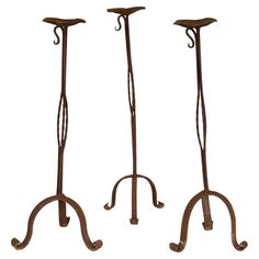 three wrought iron candle holders on stands