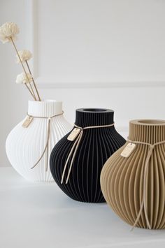 three vases are lined up on the table