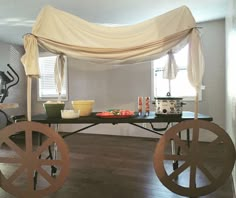 a table that has some wheels on it in the middle of a room with a canopy over it