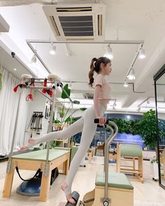 a woman is standing on a machine in a room