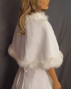 a mannequin wearing a white dress and fur stole with an open collar, standing in front of a gray background