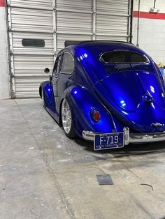 a blue vw bug is parked in a garage