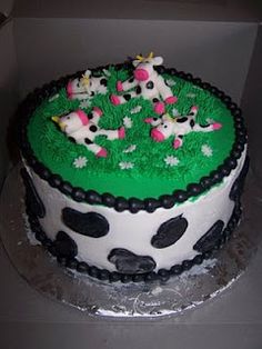 there is a cake that looks like it has cows on it and grass in the middle