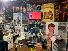 a cluttered room with posters and pictures on the wall