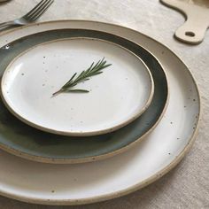 a plate with a sprig of rosemary on it sitting on a table cloth