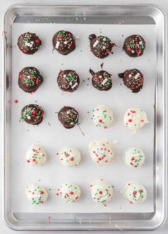 a tray filled with chocolate covered desserts and sprinkles on top of it