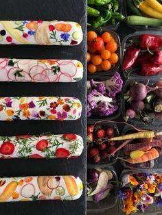 an assortment of fruits and vegetables are arranged in plastic trays on a black surface