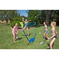 four girls are playing badminton in the yard