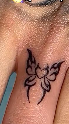 a close up of a person's wrist with a butterfly tattoo on the side