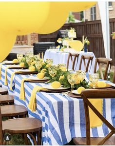 a table set up with yellow and blue striped linens for a party or celebration