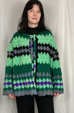 This cardigan is so bright and bold. The bright green and purple colours are stunning together. The bright colours and wool knit makes this perfect to throw on during chilly evenings, and it will take you right through to winter weather too! The knitted squares are very jolly and as it was a handknit, nobody else will have anything like this! Crochet cardigans are trendy so you will find yourself reaching for this one all the time. I upcycled and handmade this Melissa cardigan from a vintage han Green Knitted Cozy Cardigan, Cozy Green Knitted Cardigan, Green Chunky Knit Winter Cardigan, Winter Green Chunky Knit Cardigan, Green Chunky Knit Outerwear For Spring, Cozy Green Knitted Outerwear, Green Knitted Outerwear, Green Long Sleeve Knit Outerwear, Green Knitted Bohemian Outerwear