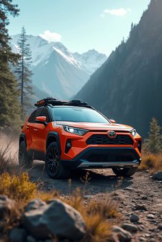 an orange toyota rav driving down a dirt road in front of trees and mountains