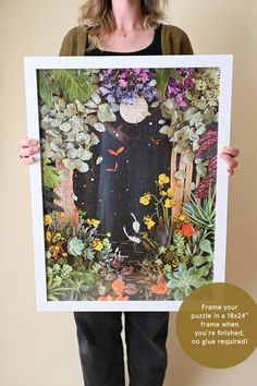 a woman holding up a painting with flowers and plants on it