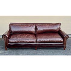 a brown leather couch sitting on top of a cement floor