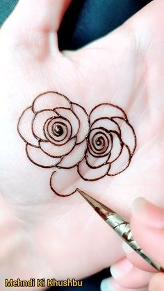 a person holding a pair of scissors in their hand with a rose tattoo on it