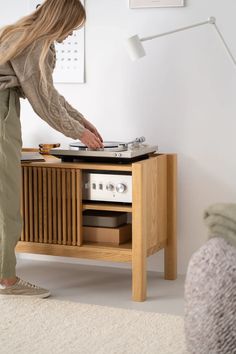 a woman standing next to a table with a record player on it