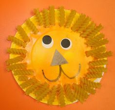 a paper plate with a lion face made out of pine cones on top of it