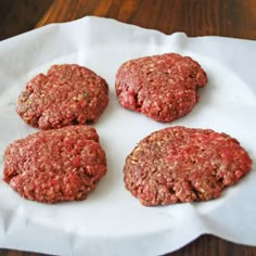 four hamburger patties sitting on top of a white paper