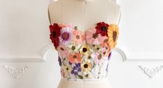 a white mannequin with colorful flowers on it's chest and bustle