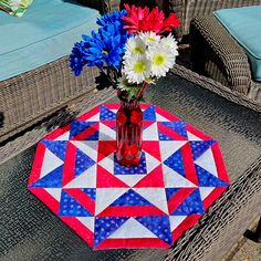 a vase filled with flowers sitting on top of a table next to wicker chairs