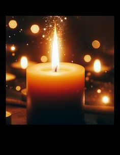 a lit candle sitting on top of a table with blurry lights in the background