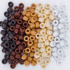 there are many different colors of beads on the white surface, one is brown and one is white