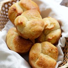 some bread rolls are in a basket on a table