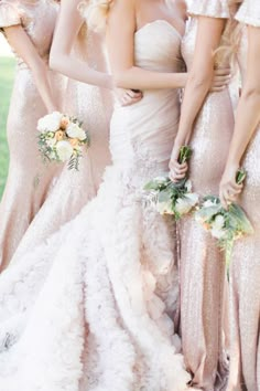 a group of women standing next to each other wearing dresses and holding bouquets in their hands