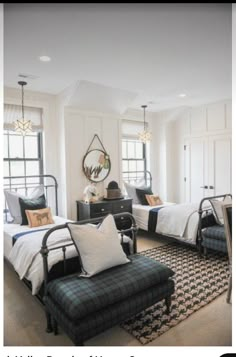 two beds in a room with white walls and black furniture on either side of them