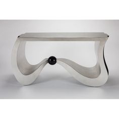 a white table with a black ball sitting on it's end and an artistic design in the middle