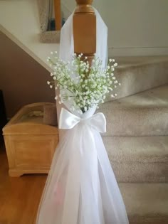 a bouquet of baby's breath sitting on top of a wooden table next to stairs