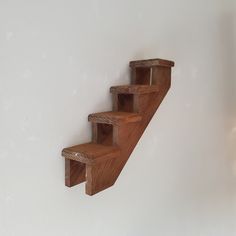 a wooden shelf sitting on the side of a wall