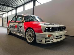 a red and white car parked in a garage