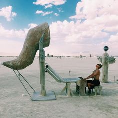 a man sitting on a bench next to a sculpture