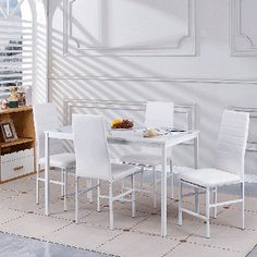 a white dining table and chairs in a room with an area rug on the floor