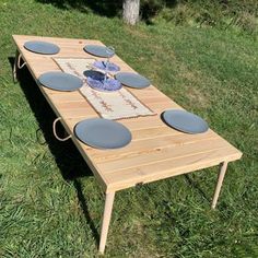 a wooden table with plates on it in the grass