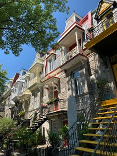 a row of multi - story townhouses with balconies and yellow steps leading up to them